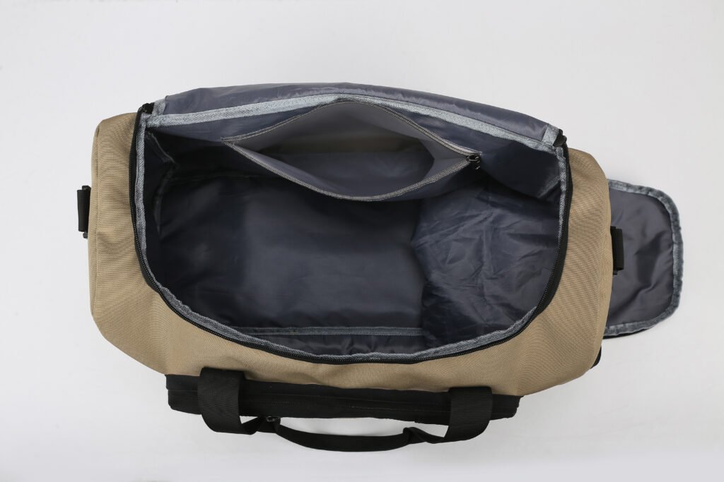 Top view into the open interior of a khaki travel duffel bag