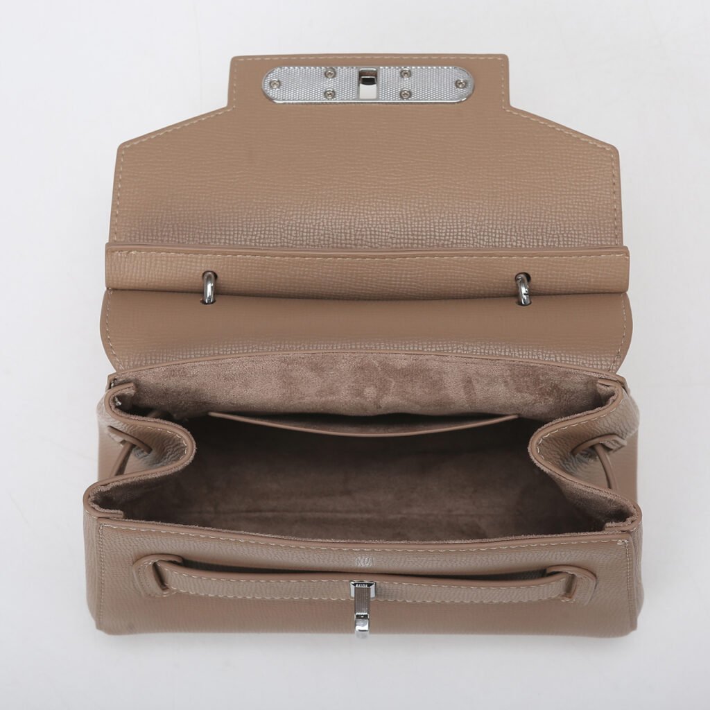 Open interior of a taupe structured satchel with divided compartments