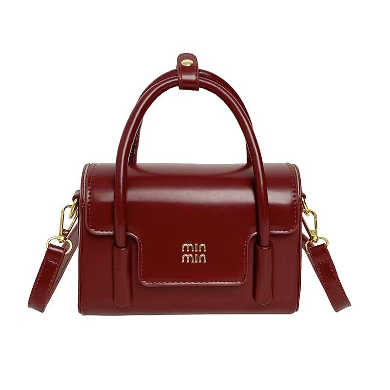 Burgundy structured handbag with top handles and shoulder strap