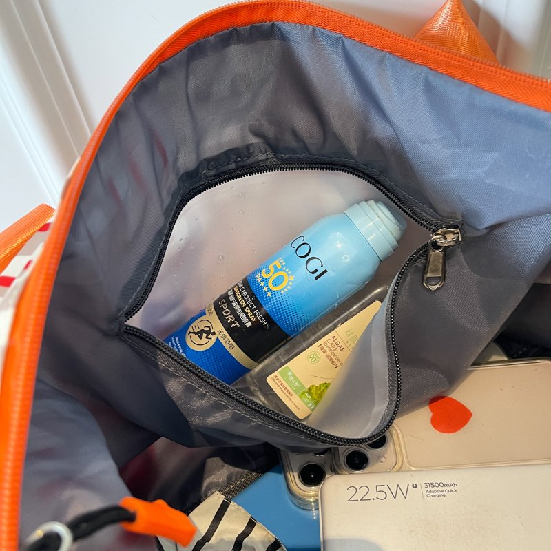 Open cosmetic bag showing gray lining and an inner zipper pocket