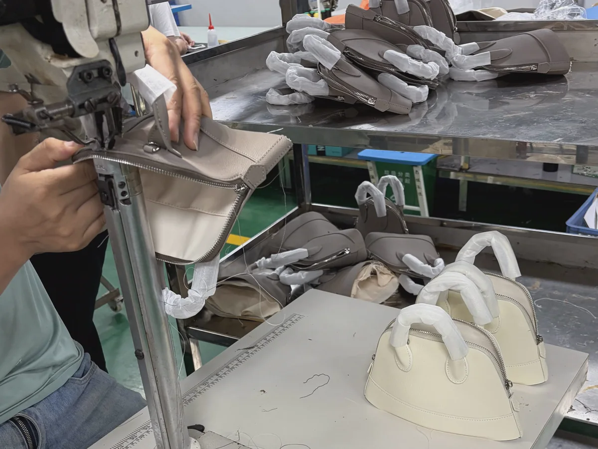 Bag panels being sewn and assembled at a production workstation