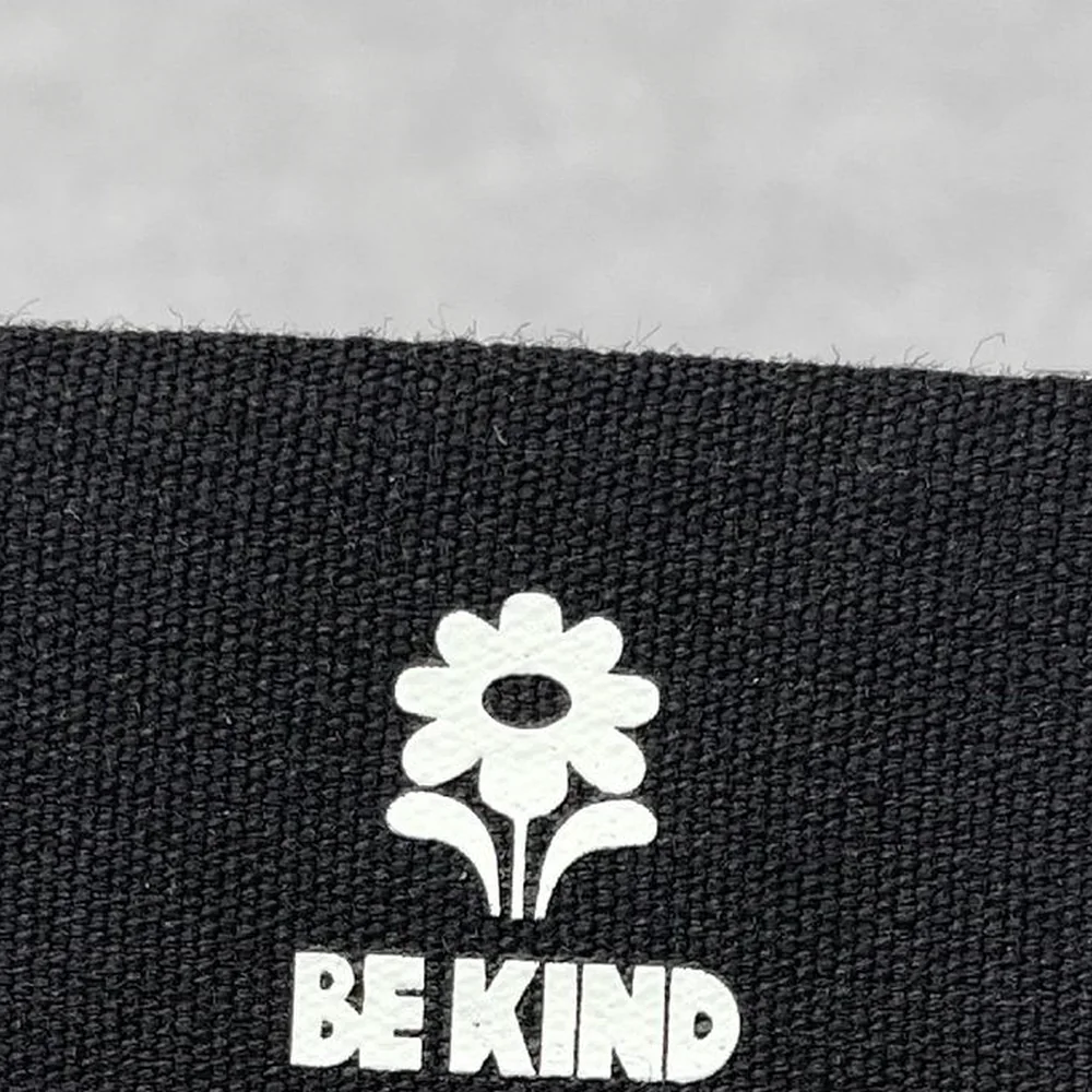 White screen-printed ink detail on black woven fabric