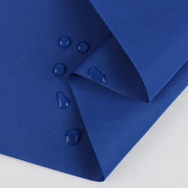 Water droplets beading on the surface of blue fabric