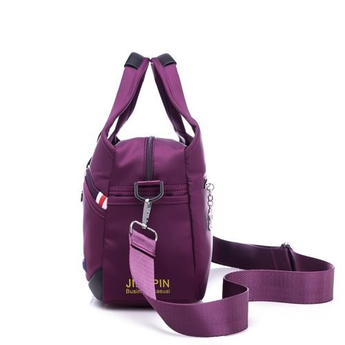 Side view of a purple multi-pocket shoulder bag and strap