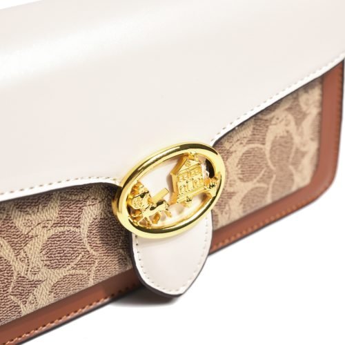 Close-up of the round metal clasp on a patterned flap shoulder bag